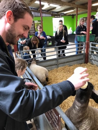 Jason feeding a young lamb some milk